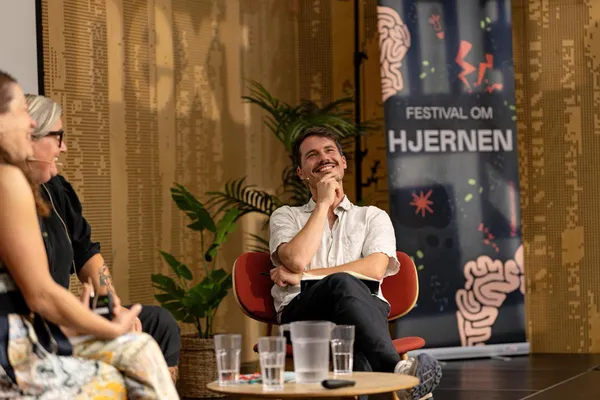 Noa Kjærsgaard Hansen smiler under en samtale på scenen ved Festival om Hjernen